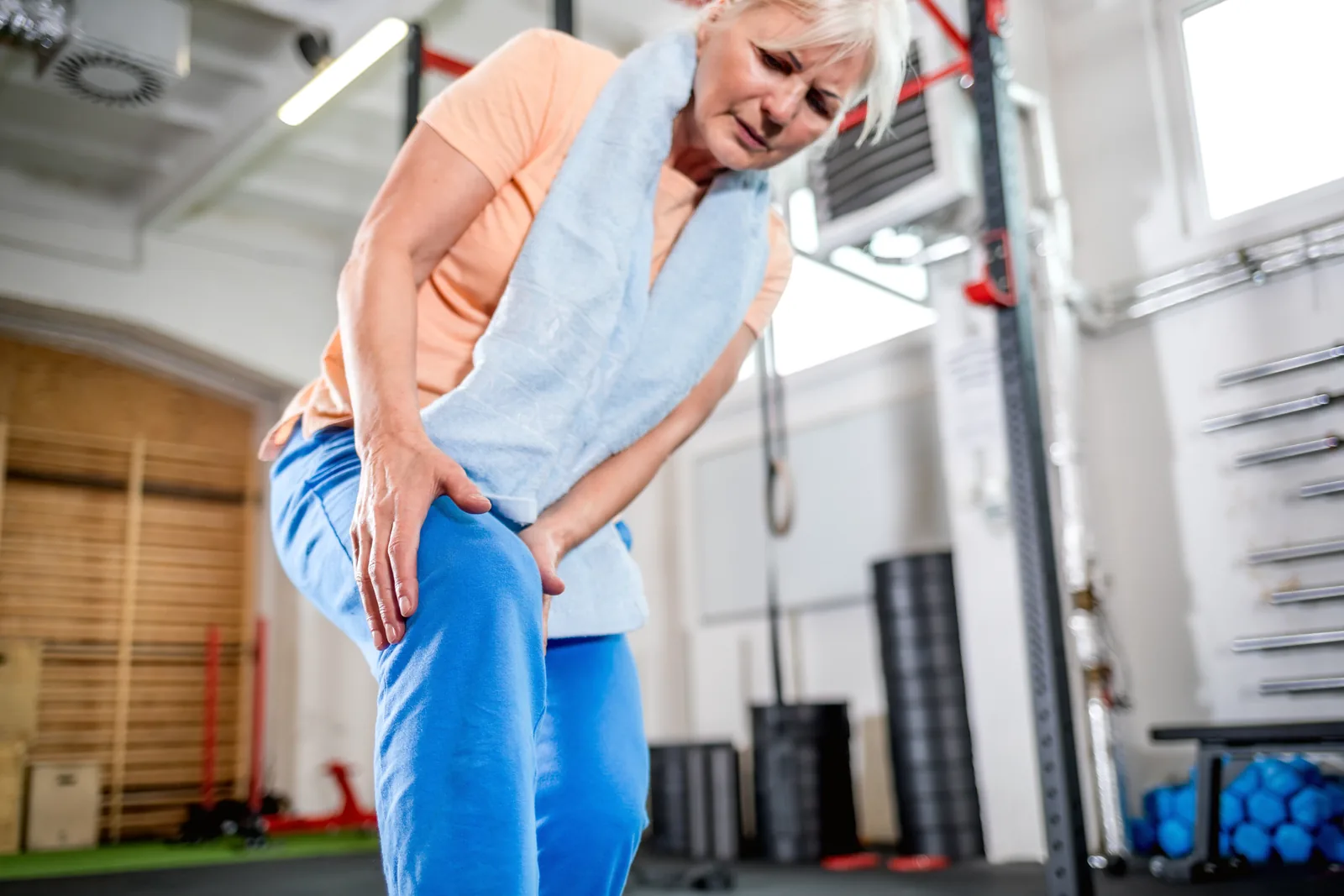 A senior man working with dumbbells alongside a healthcare worker